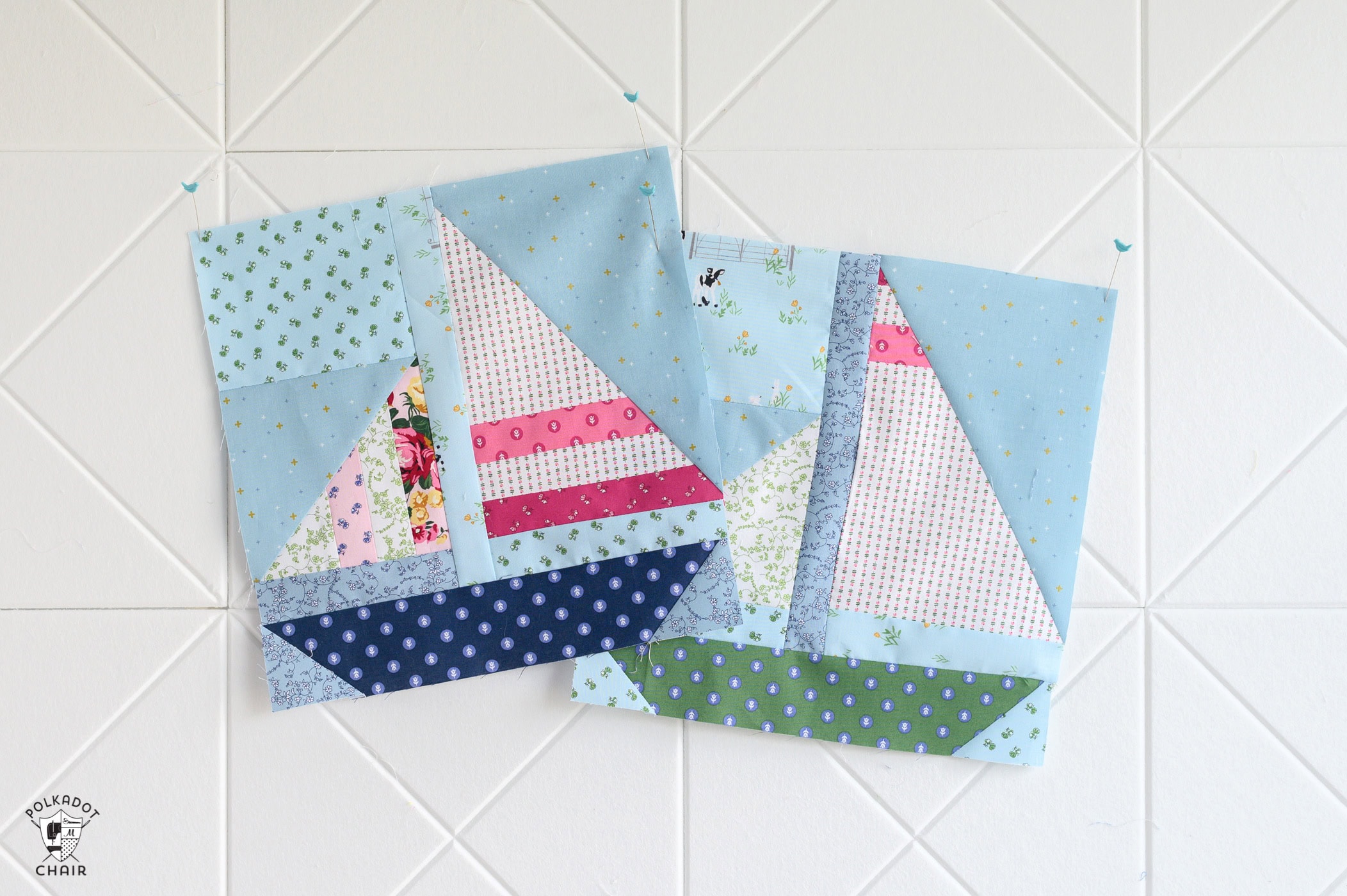 two sailboat quilt blocks on white pinboard