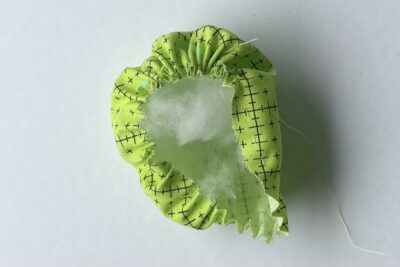 green circle fabric after being gathered with stuffing