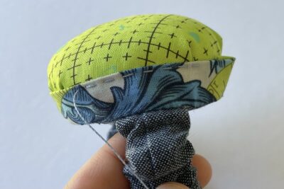 blue and green pincushion during construction steps