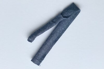 blue fabric strip on white table with pins and thread
