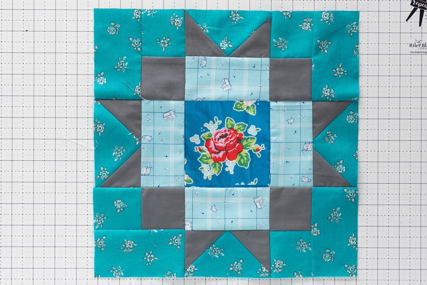 aqua blue and gray maple star quilt block on white cutting mat