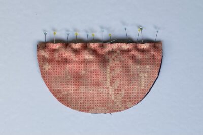 ribbon and felt pinned to half circle of fabric with pins