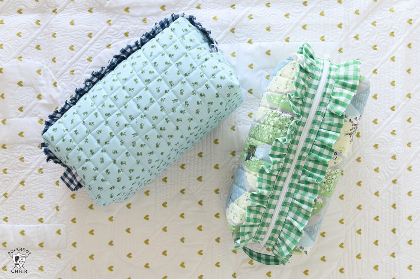 close up of two blue and green ruffle zip pouches on white quilt