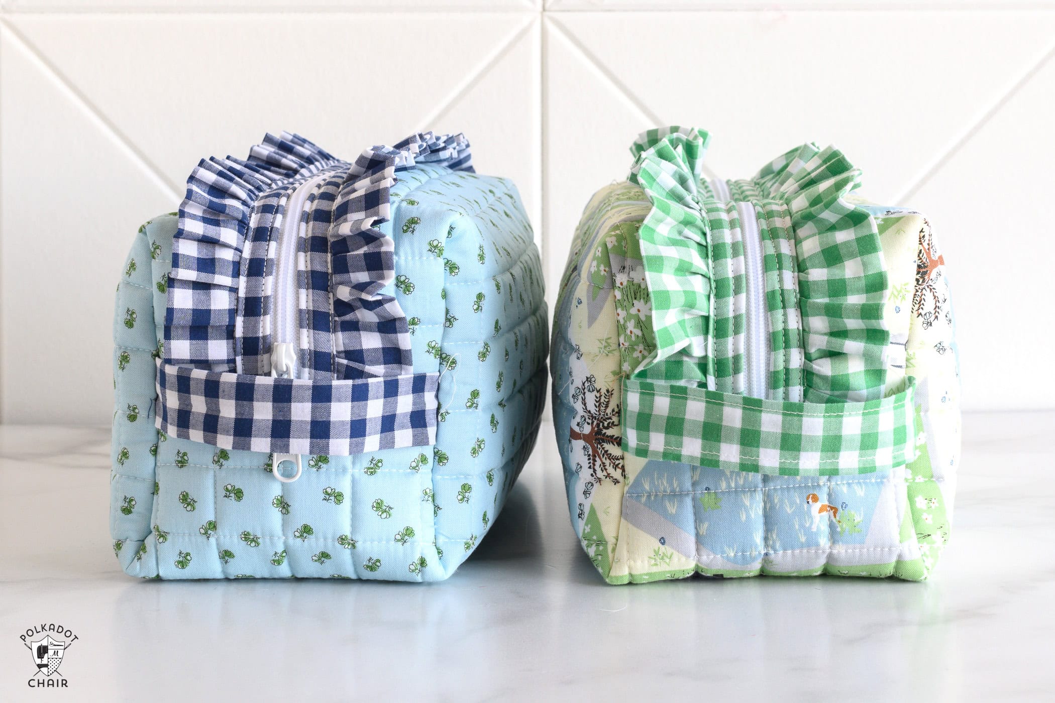 close up of two blue and green ruffle zip pouches on white table