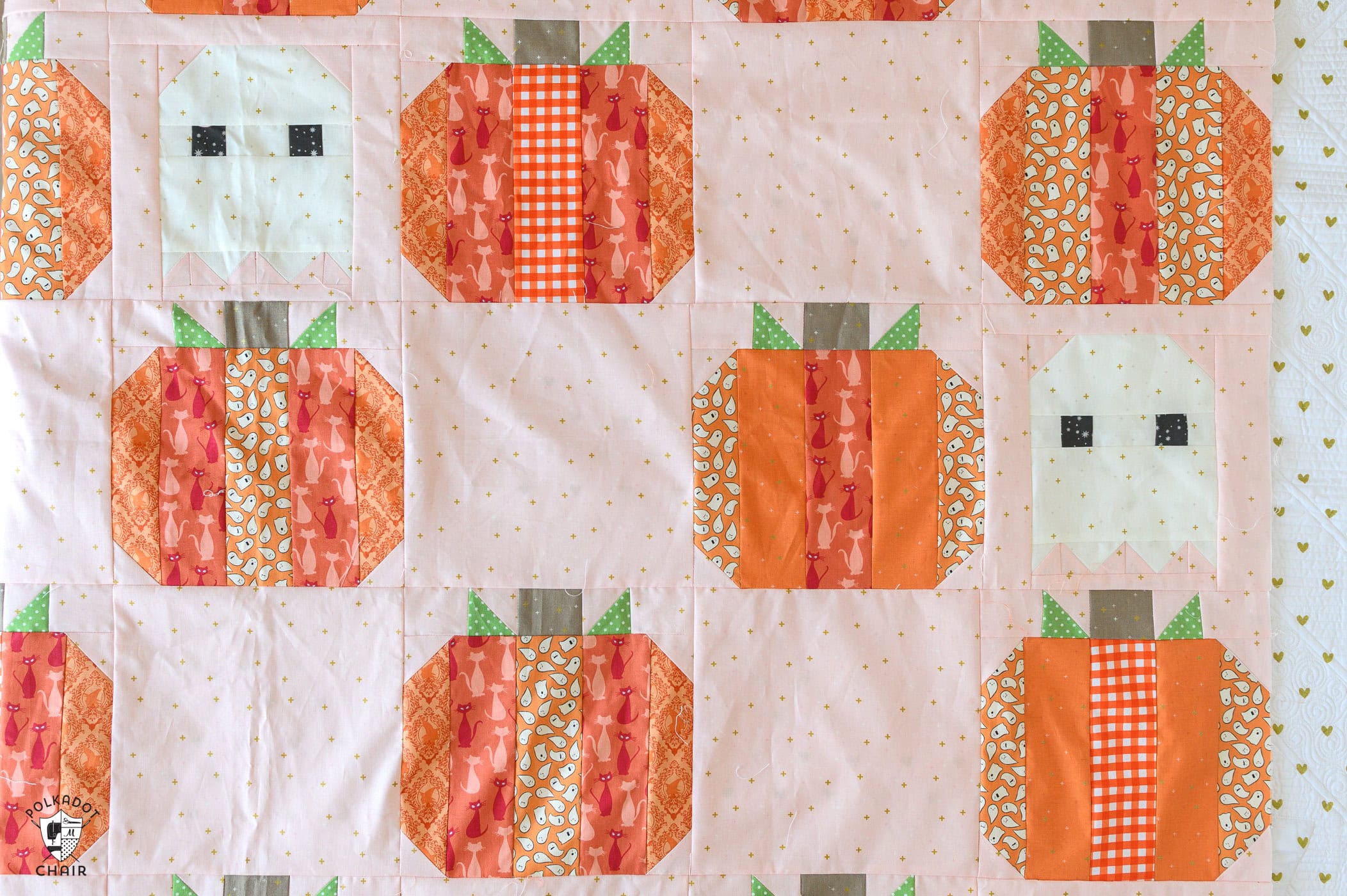 pink quilt with orange striped pumpkins and ghosts