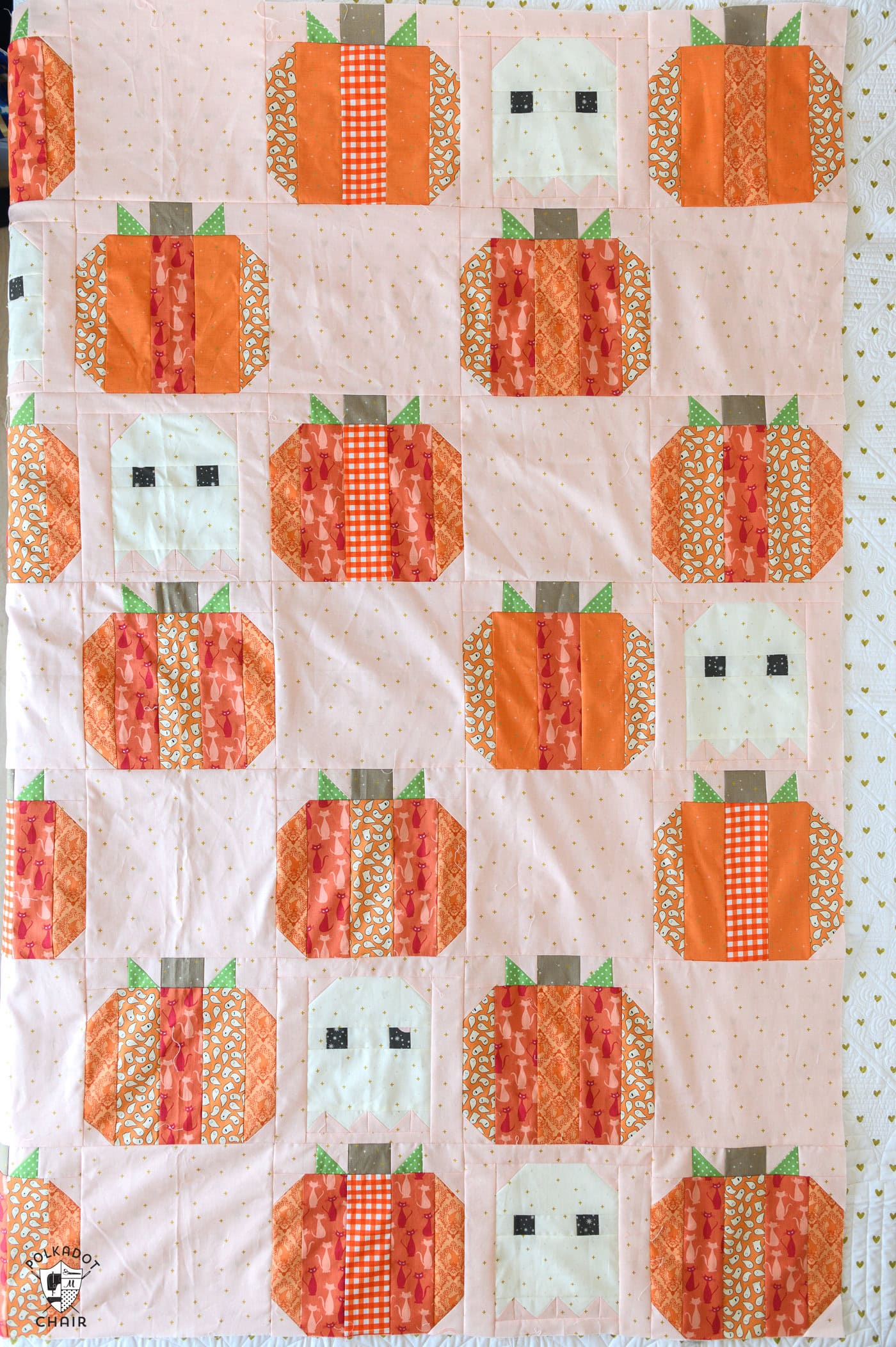 pink quilt with orange striped pumpkins and ghosts