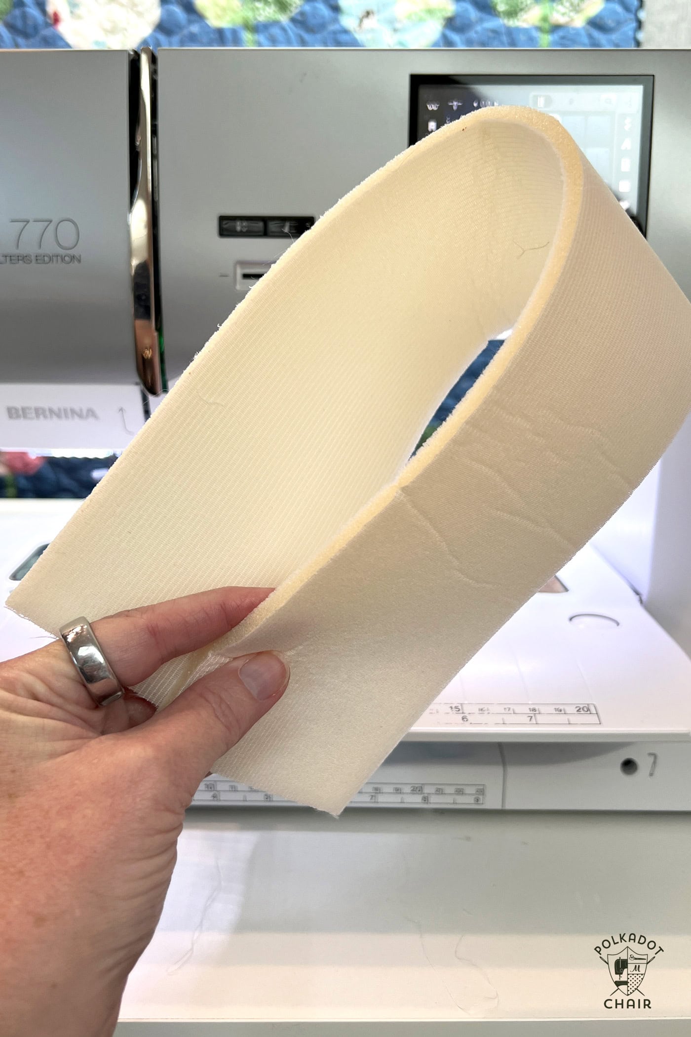 hand holding quarter inch foam in front of sewing machine