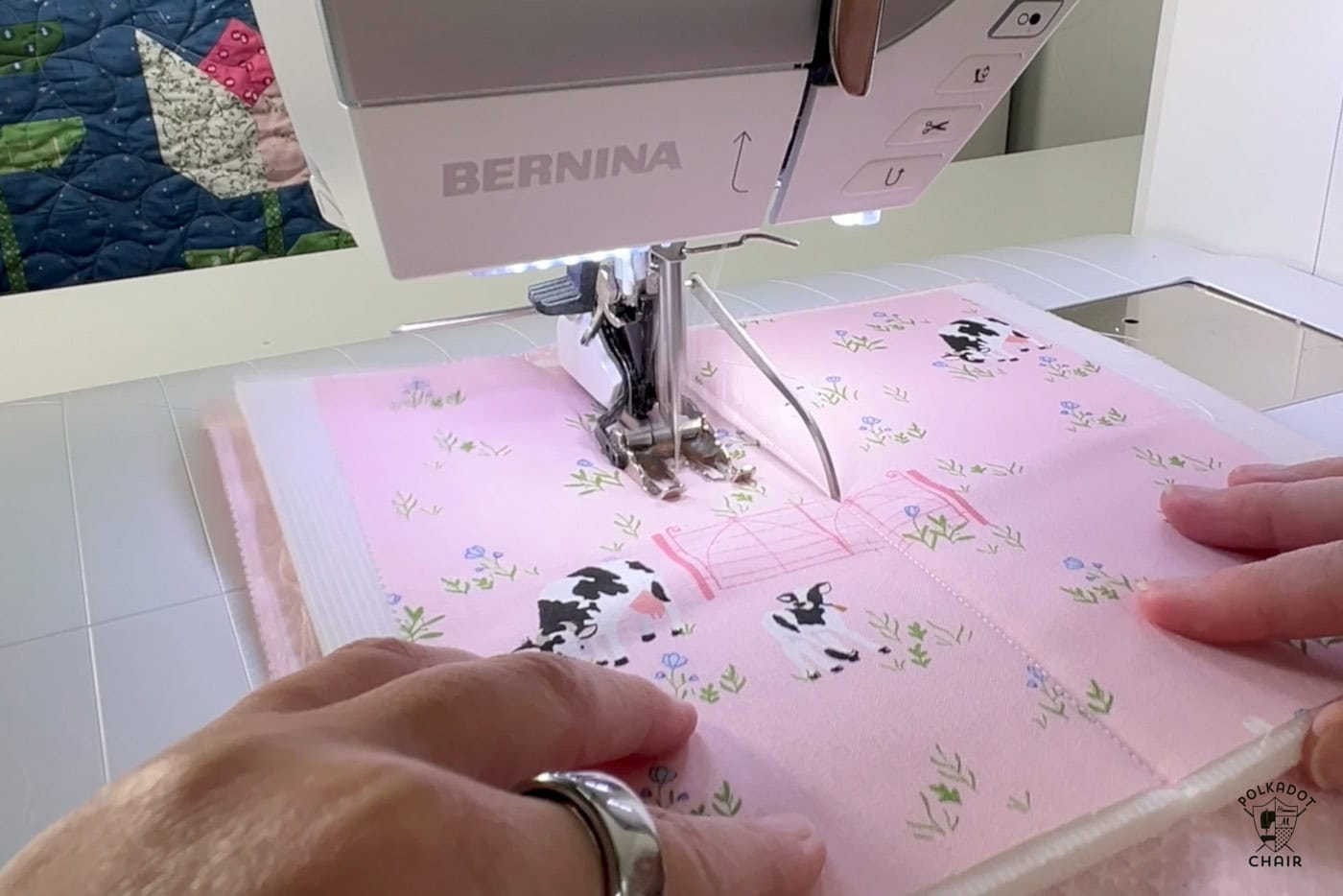 close up of walking foot on sewing machine sewing pink fabric