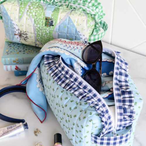 image of two ruffle zip pouches with scarf, and lip gloss on white table
