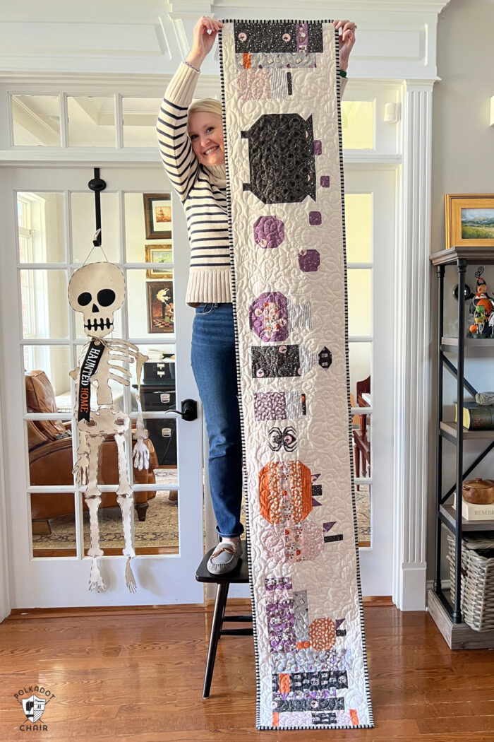 woman holding a halloween table runner