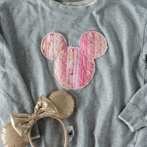 gray disney sweashirt on table with mickey ears