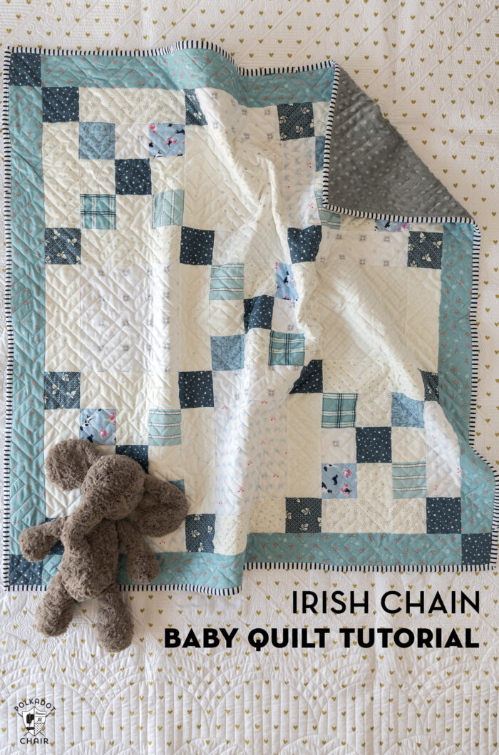 blue and ivory baby quilt on bed with gray elephant toy
