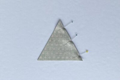 green fabric triangles on white table during construction process.