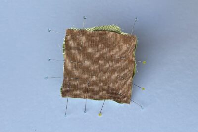 brown fabric pinned to green fabric
