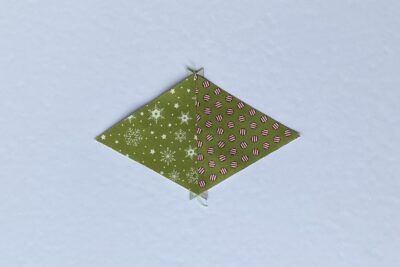 green fabric triangles on white table during construction process.