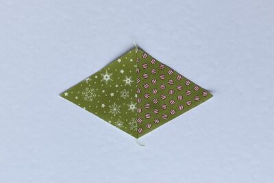 green fabric triangles on white table during construction process.