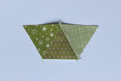 green fabric triangles on white table during construction process.