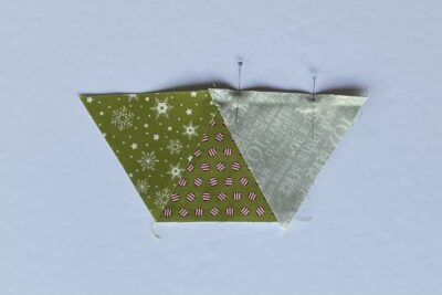 green fabric triangles on white table during construction process.