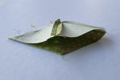 green fabric triangles on white table during construction process.