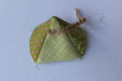 fabric pyramid on white table with brown trim pinned on