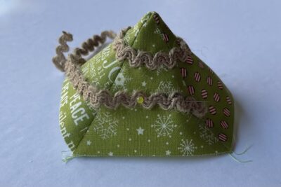 fabric pyramid on white table with brown trim pinned on