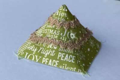 fabric pyramid on white table with brown trim pinned on