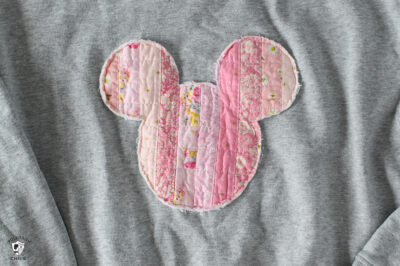 Pink Mickey mouse head shape on gray sweatshirt