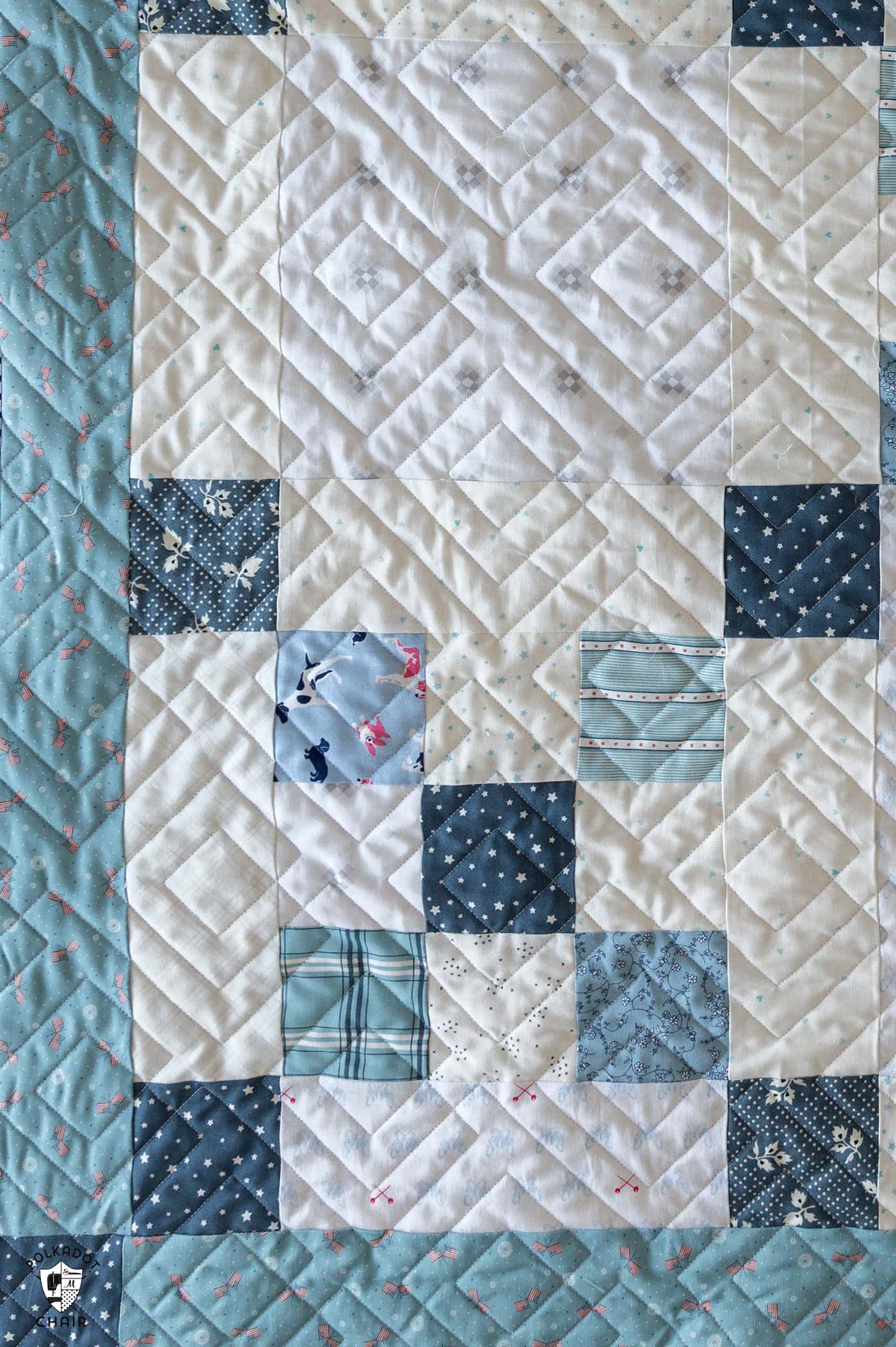 blue and ivory baby quilt on bed