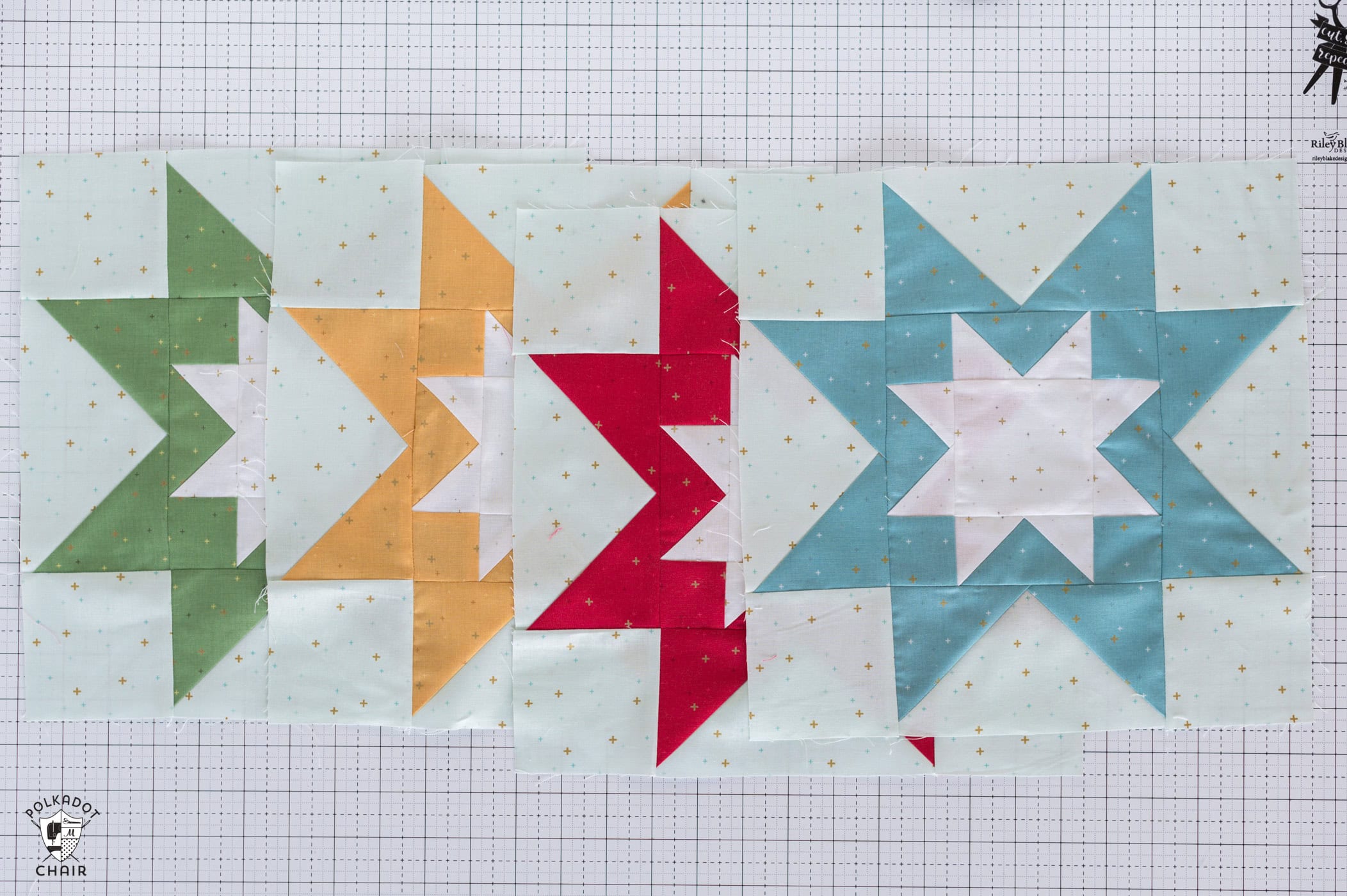 Yellow, red, green, turquoise and light mint quilt block on white cutting mat - quilt block is a star shape