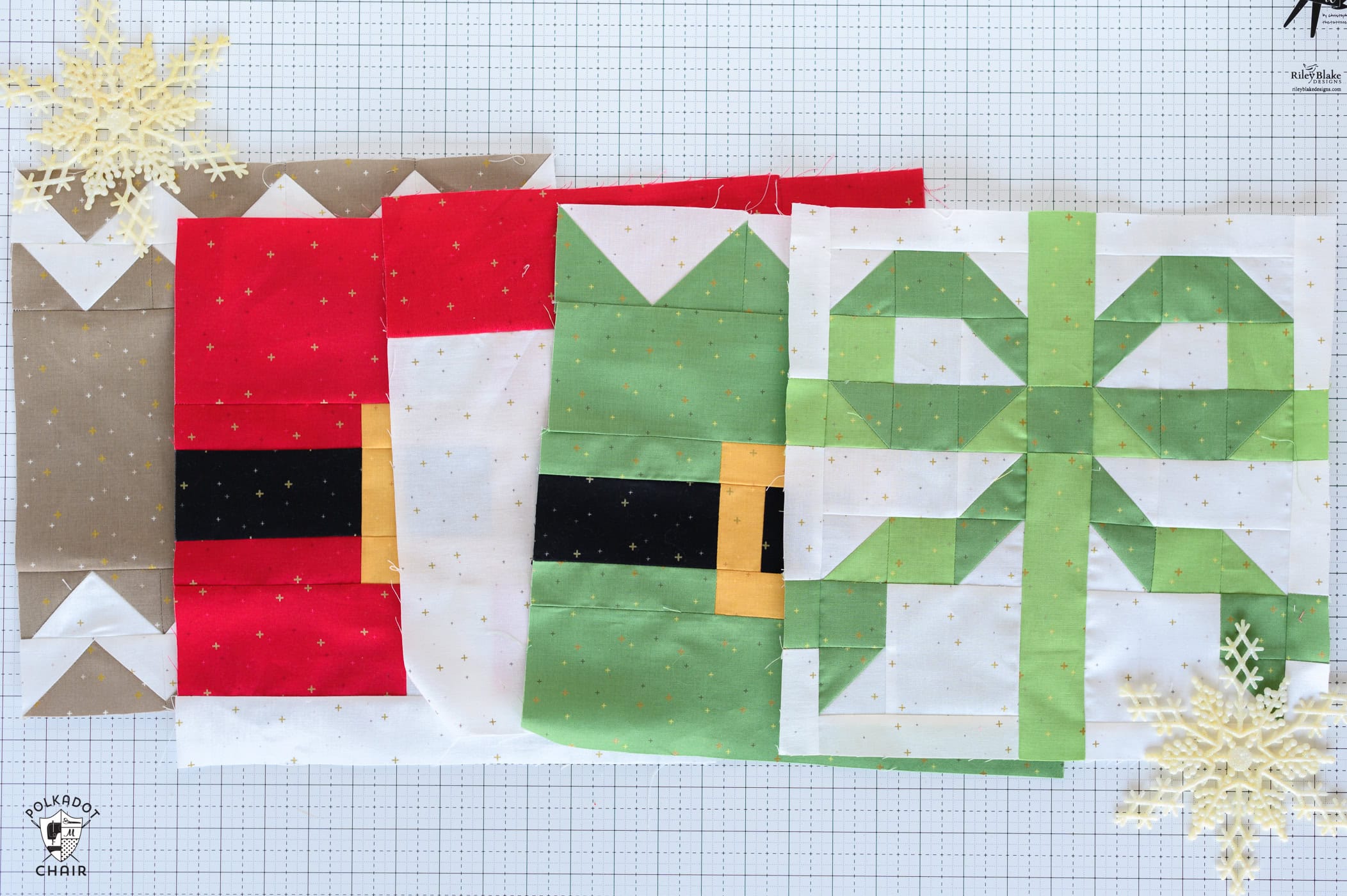 Colorful Christmas quilt blocks on white cutting mat with plastic snowflake