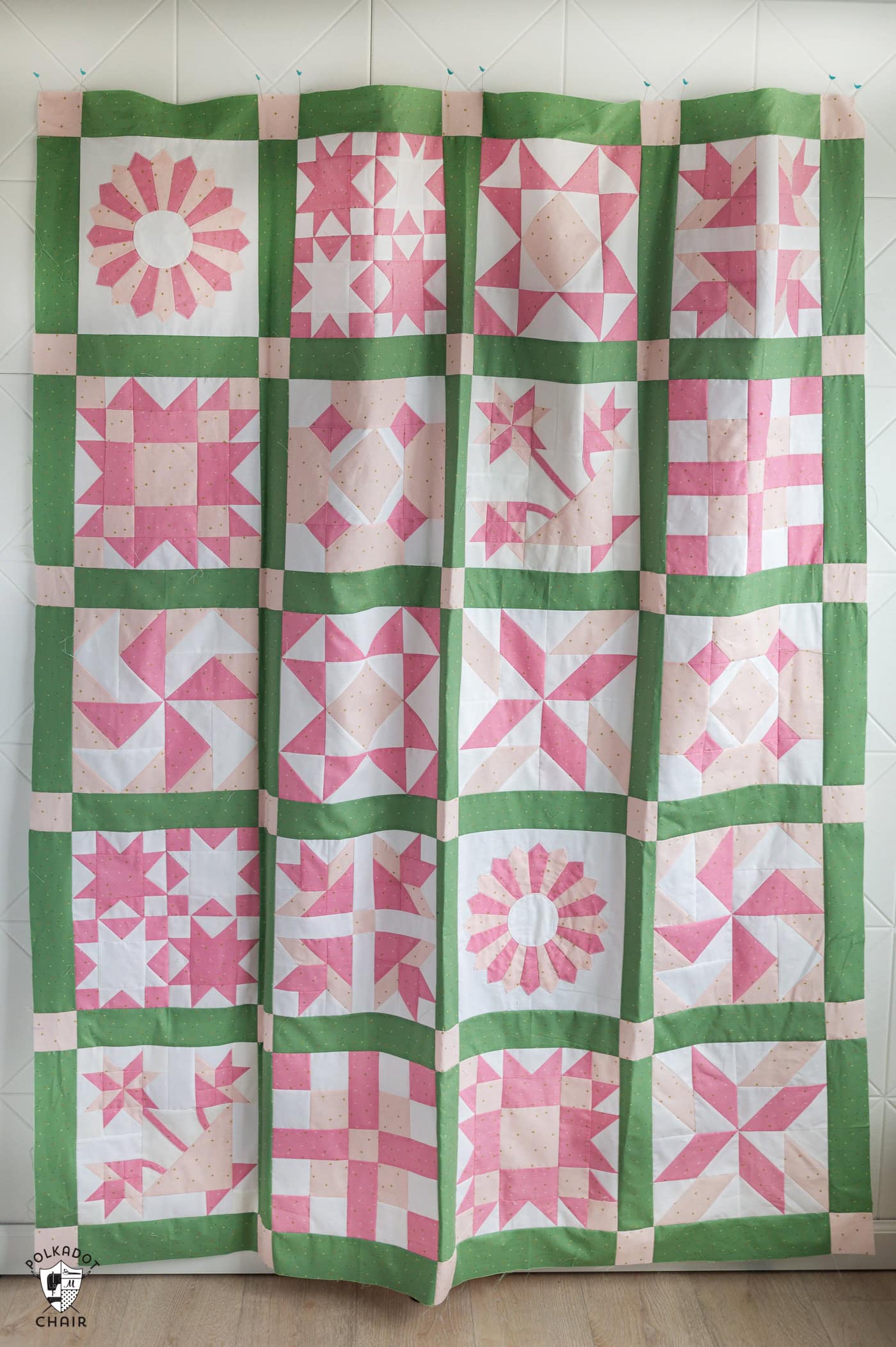 pink and green traditional quilt hanging on wall