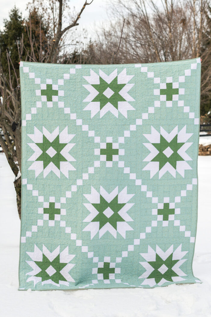 mint and green geometric quilt in snow