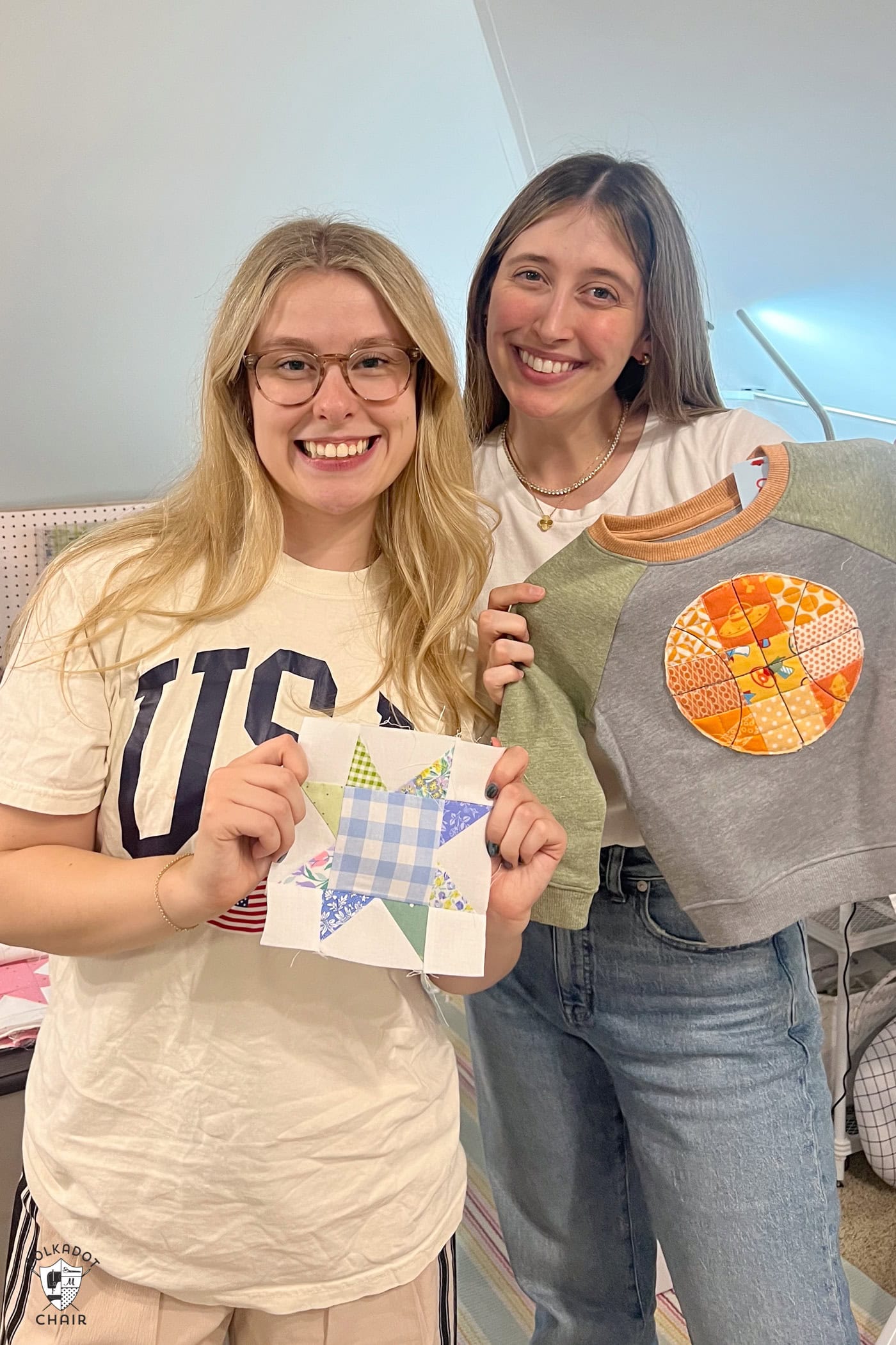 Two women holding small quilted projects