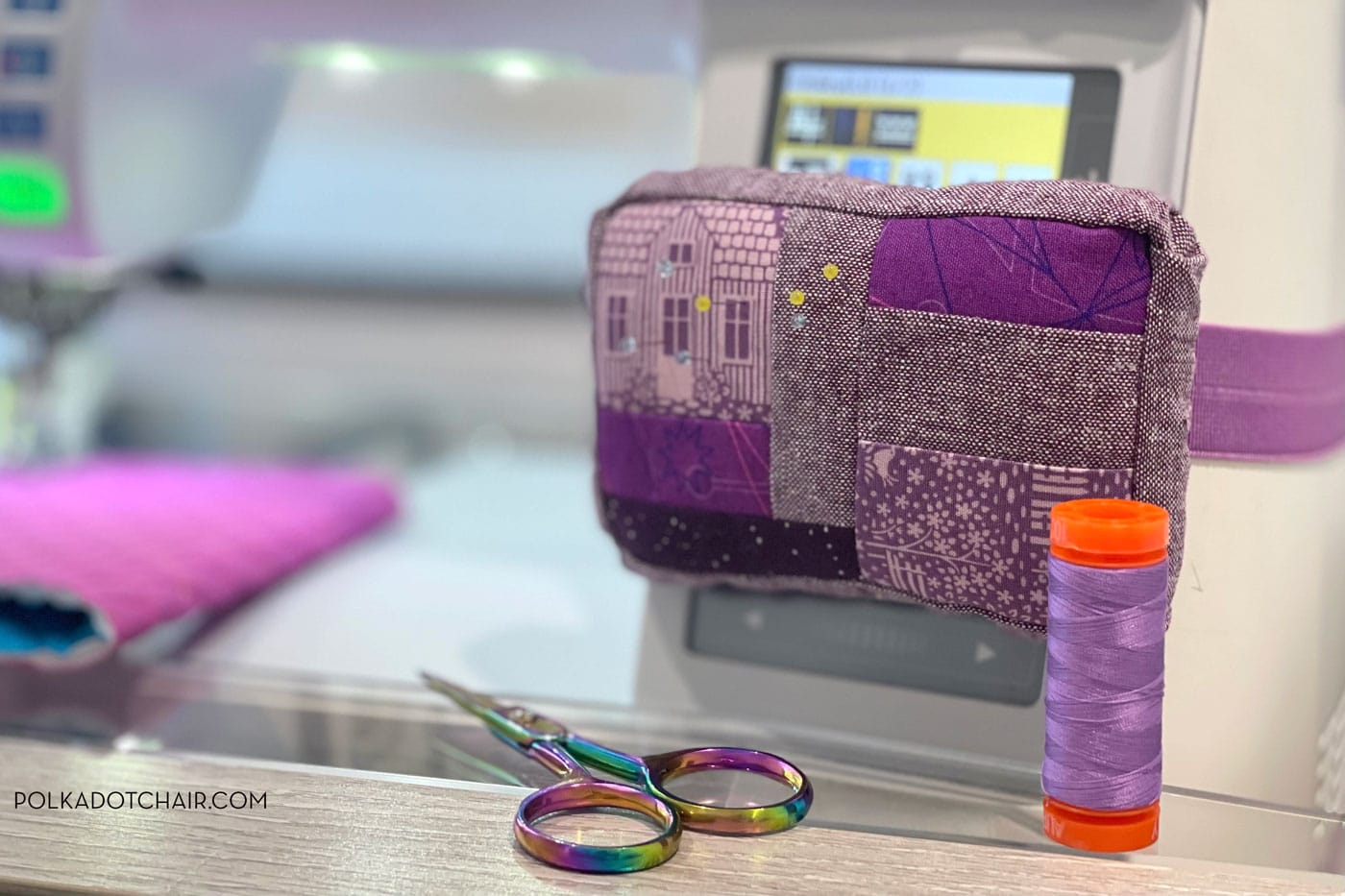 purple pincushion attached to white sewing machine with sewing notions