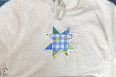 pins in quilt block on cream sweatshirt