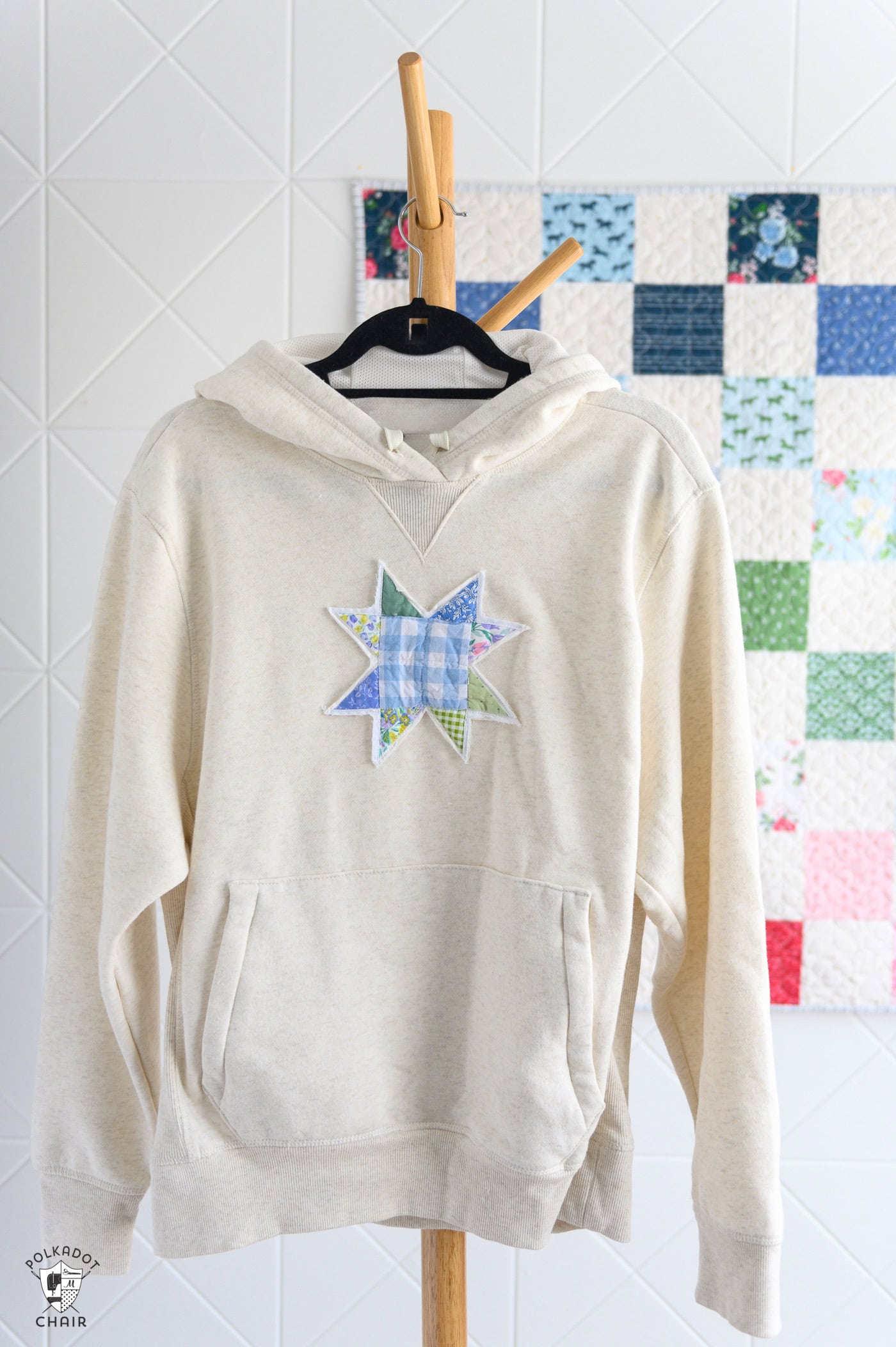 cream sweatshirt with quilt block on front in front of patchwork quilt