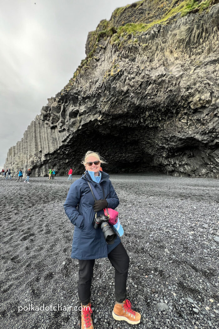 woman standing on black sand beach