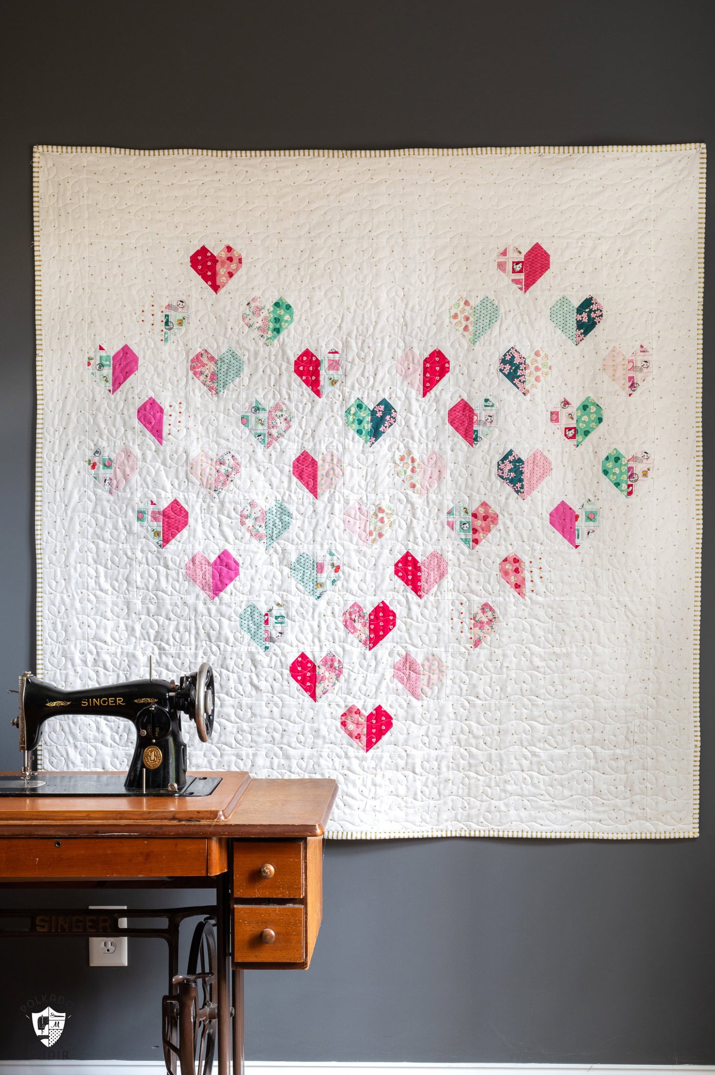 heart quilt hanging on gray wall