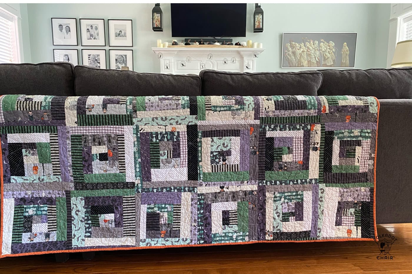 purple and green log cabin quilt on back of gray sofa