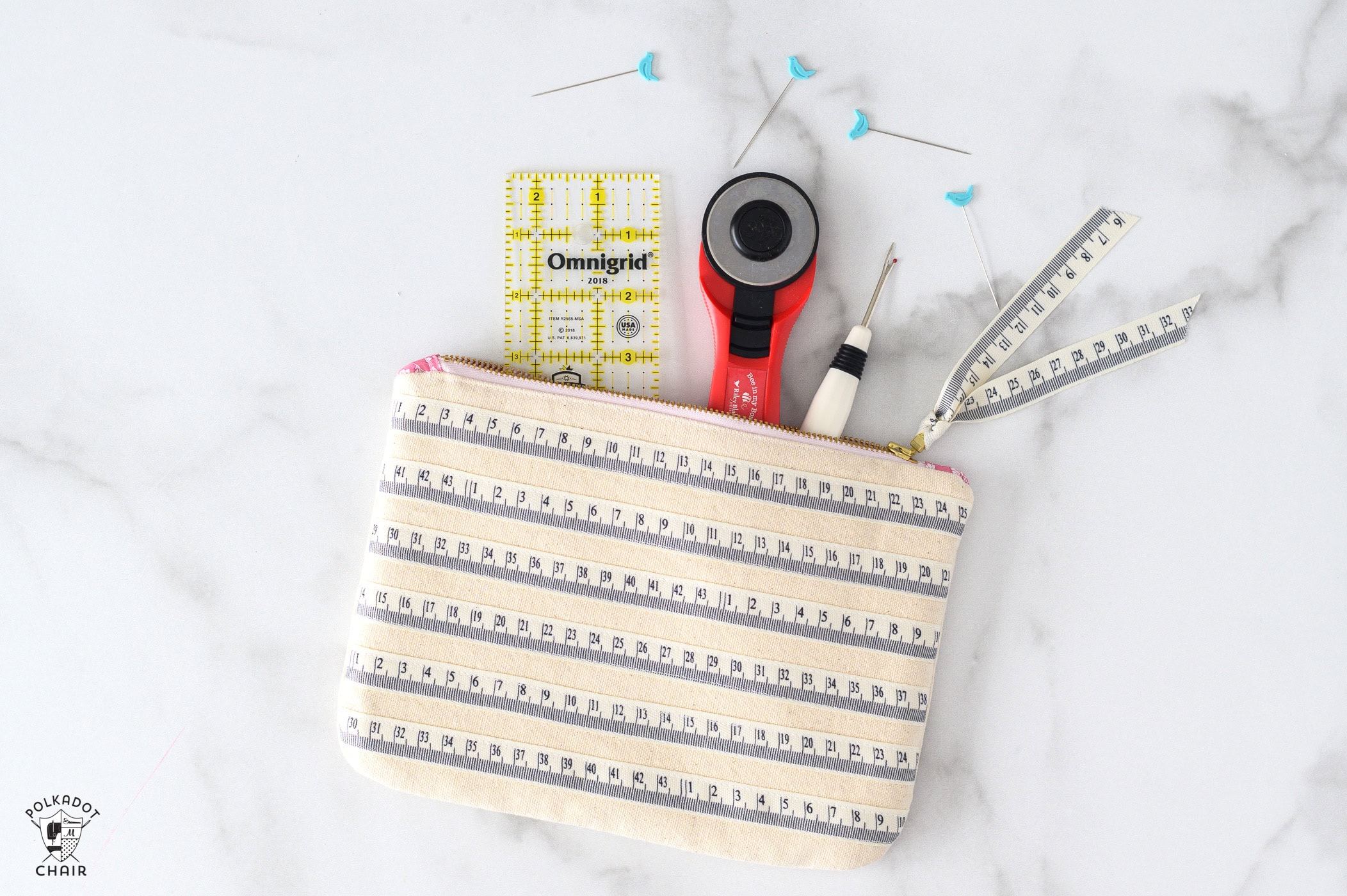 striped canvas zip bag on marble table with sewing notions