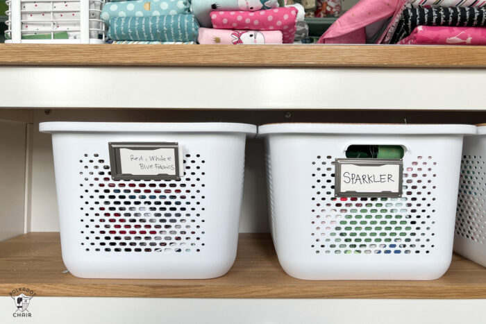 two plastic bins on shelf in sewing room with labels