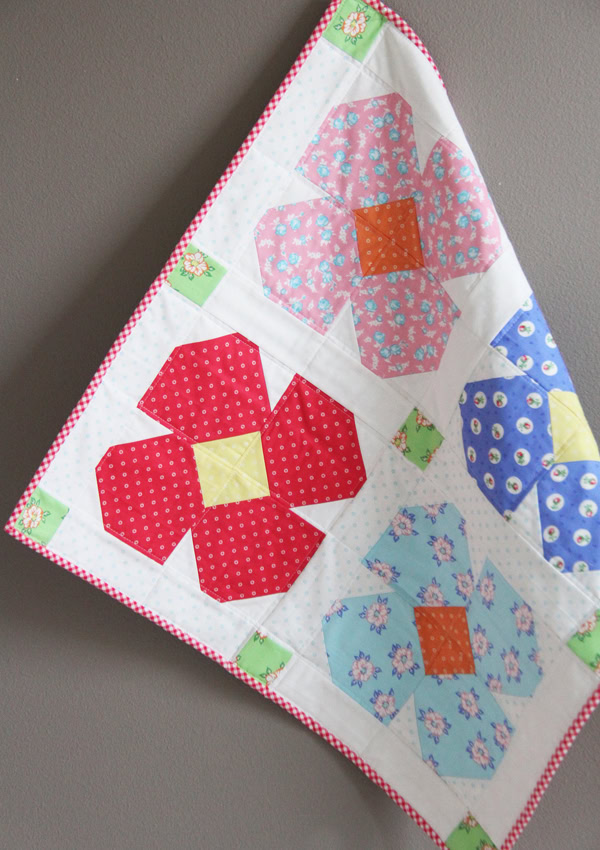 red, pink and blue flower quilt blocks on wall hanging