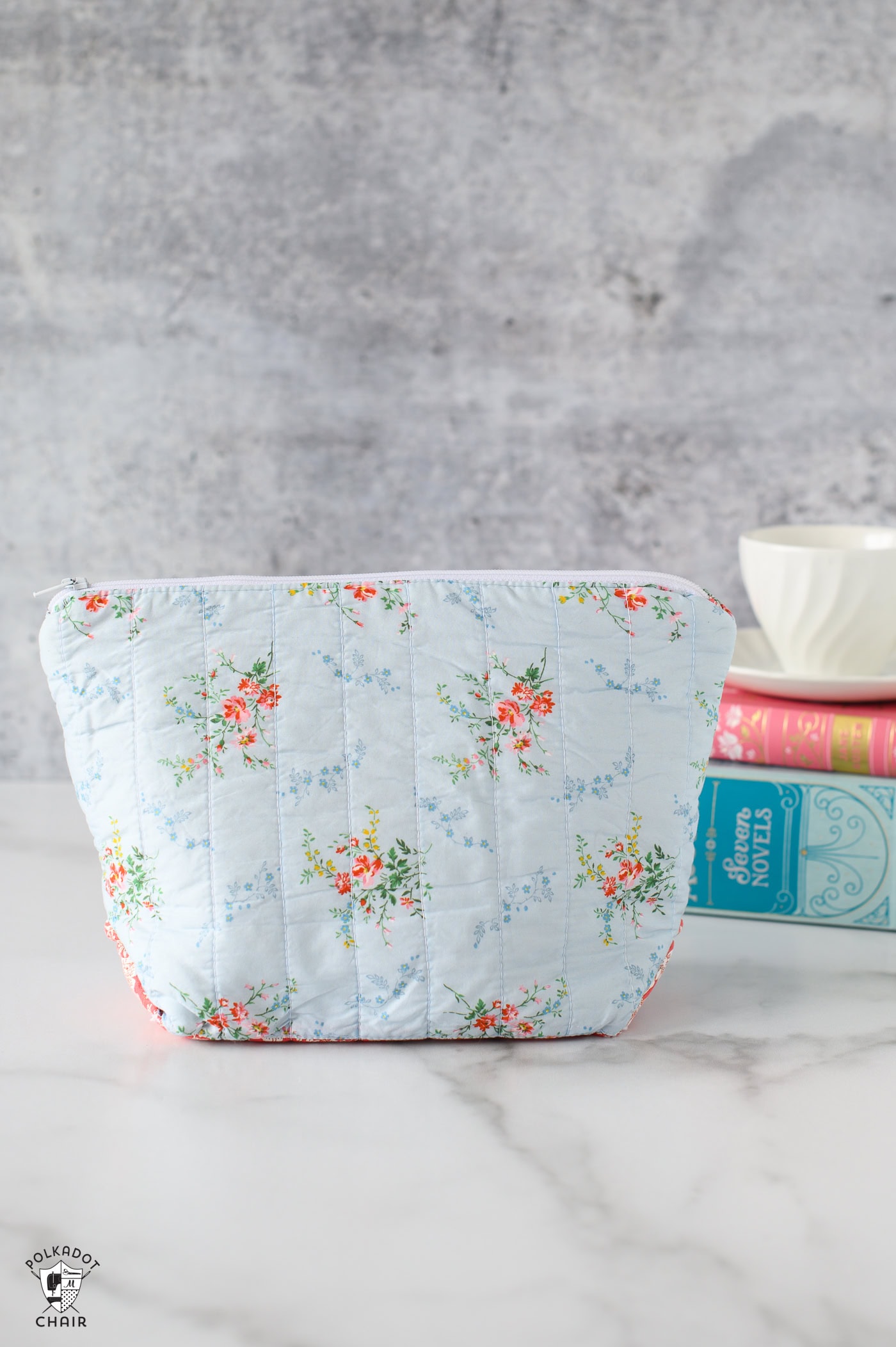 blue zippered pouch on table with books in the background