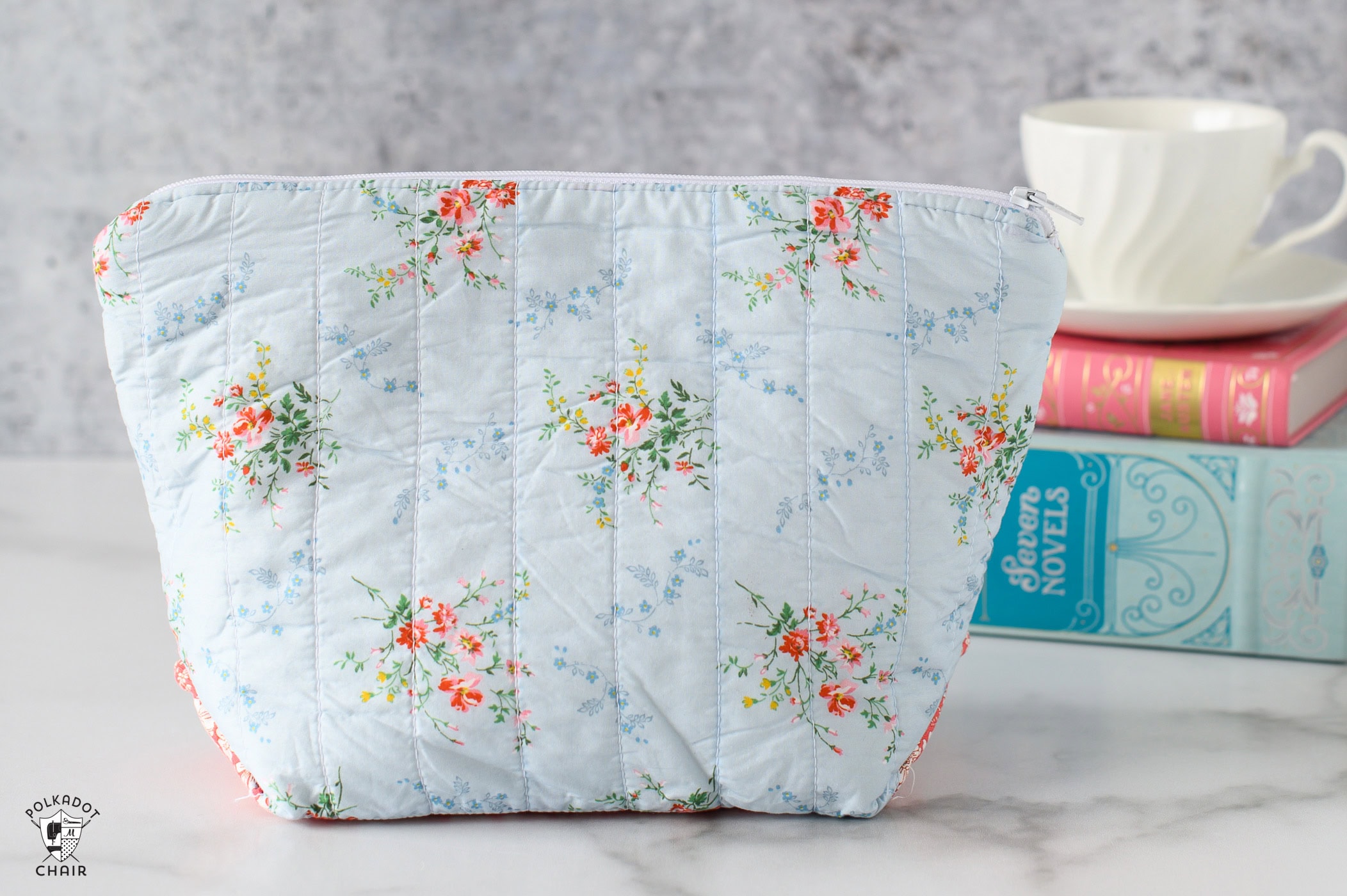 blue zippered pouch on table with books in the background