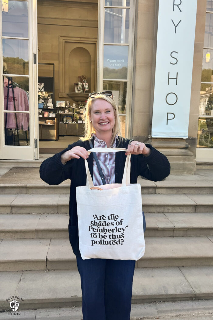 woman holding tote bag on step outside shop