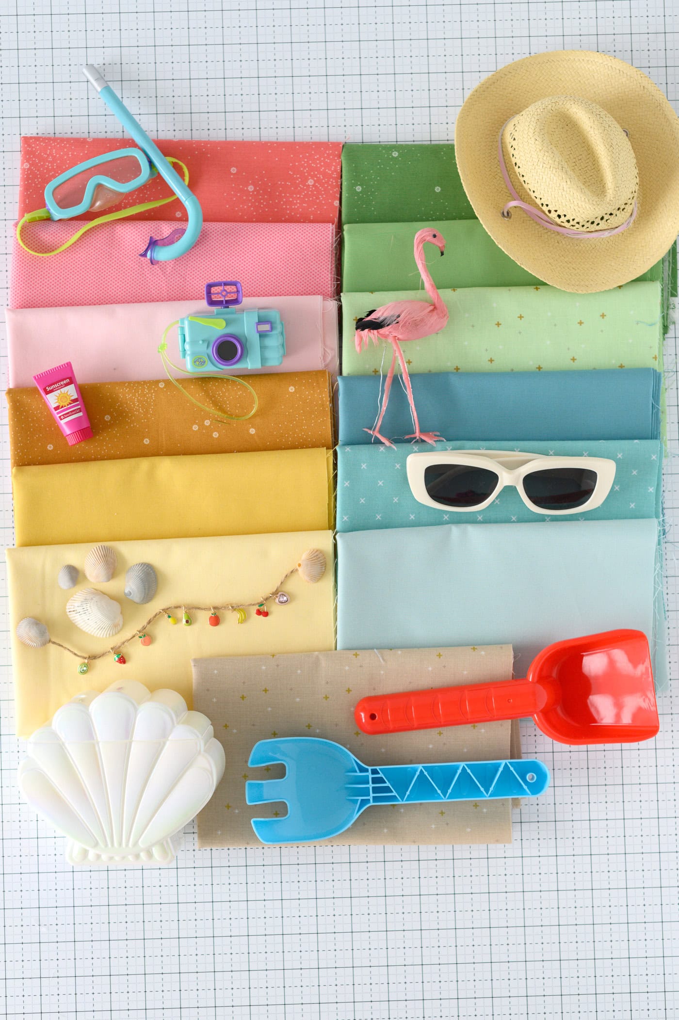 colorful fabrics on cutting mat with summer accessories