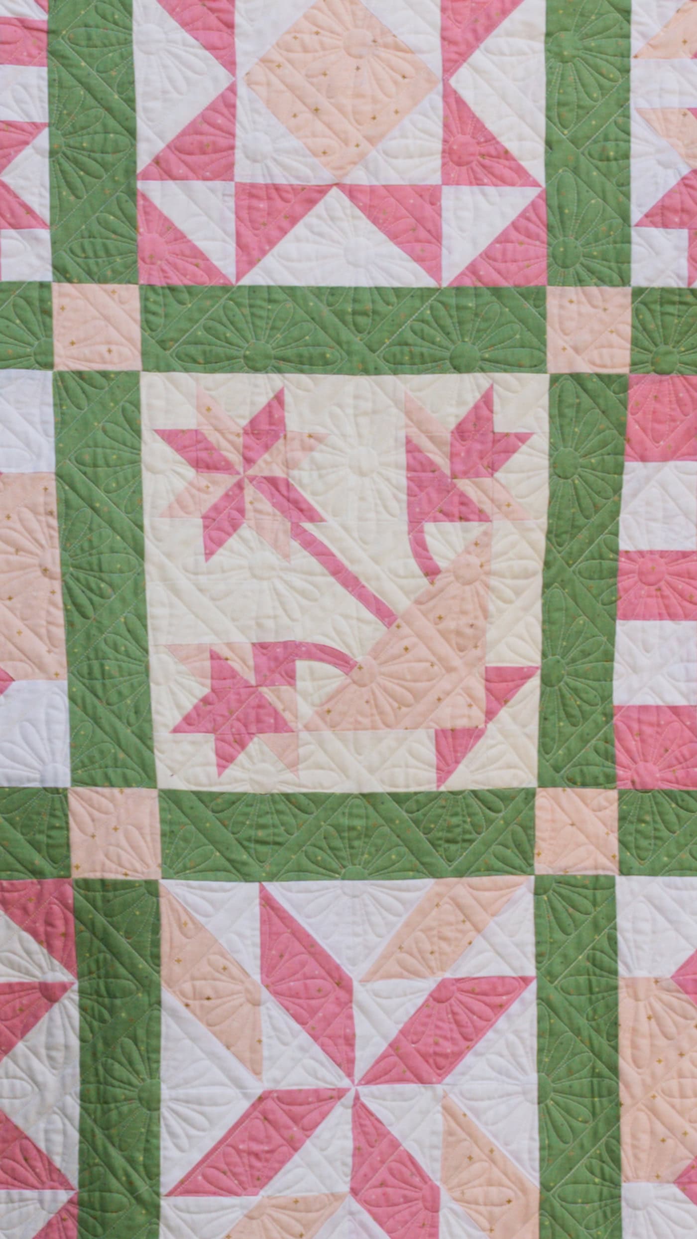 pink and green sampler quilt outdoors