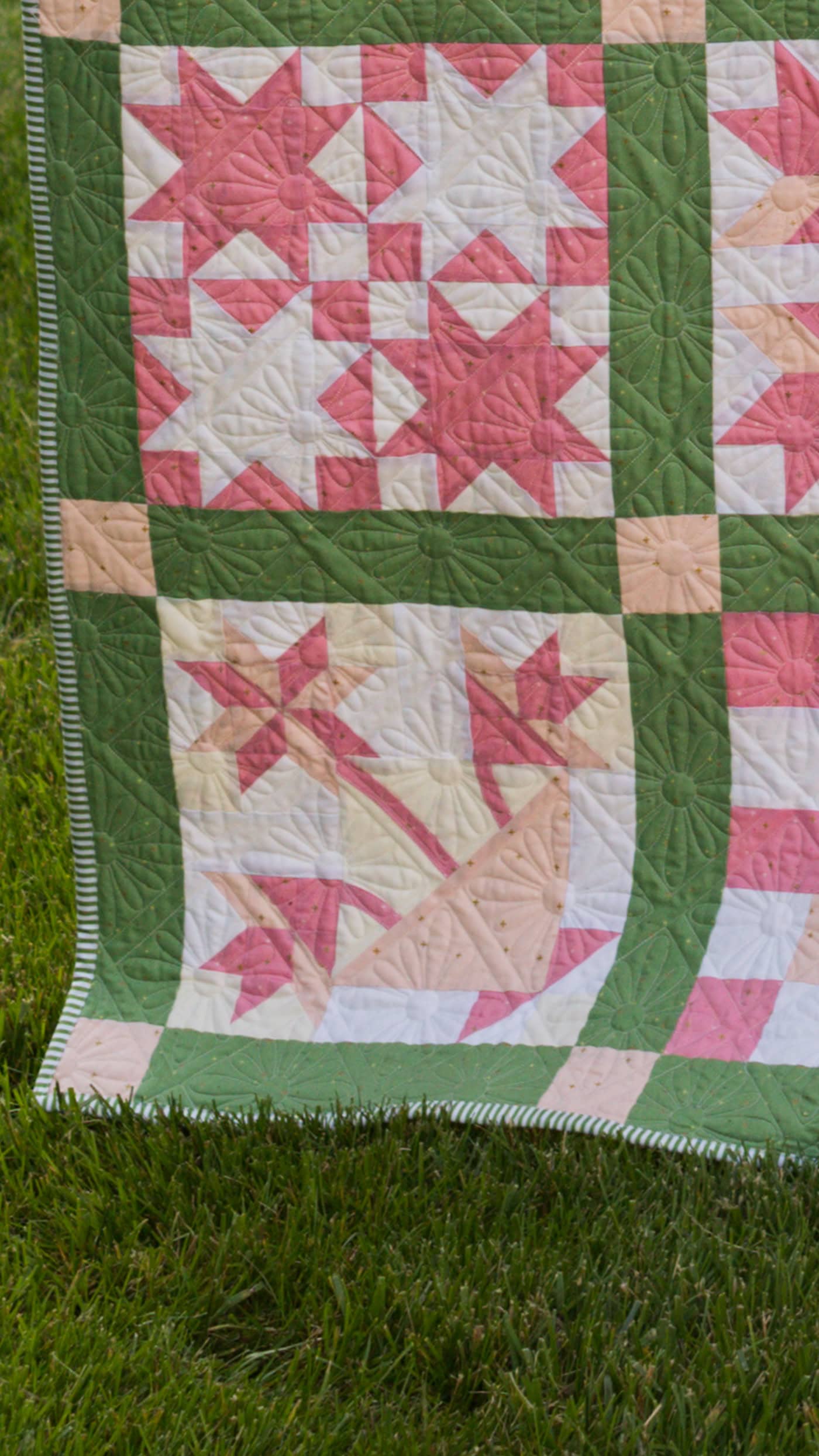 pink and green sampler quilt outdoors