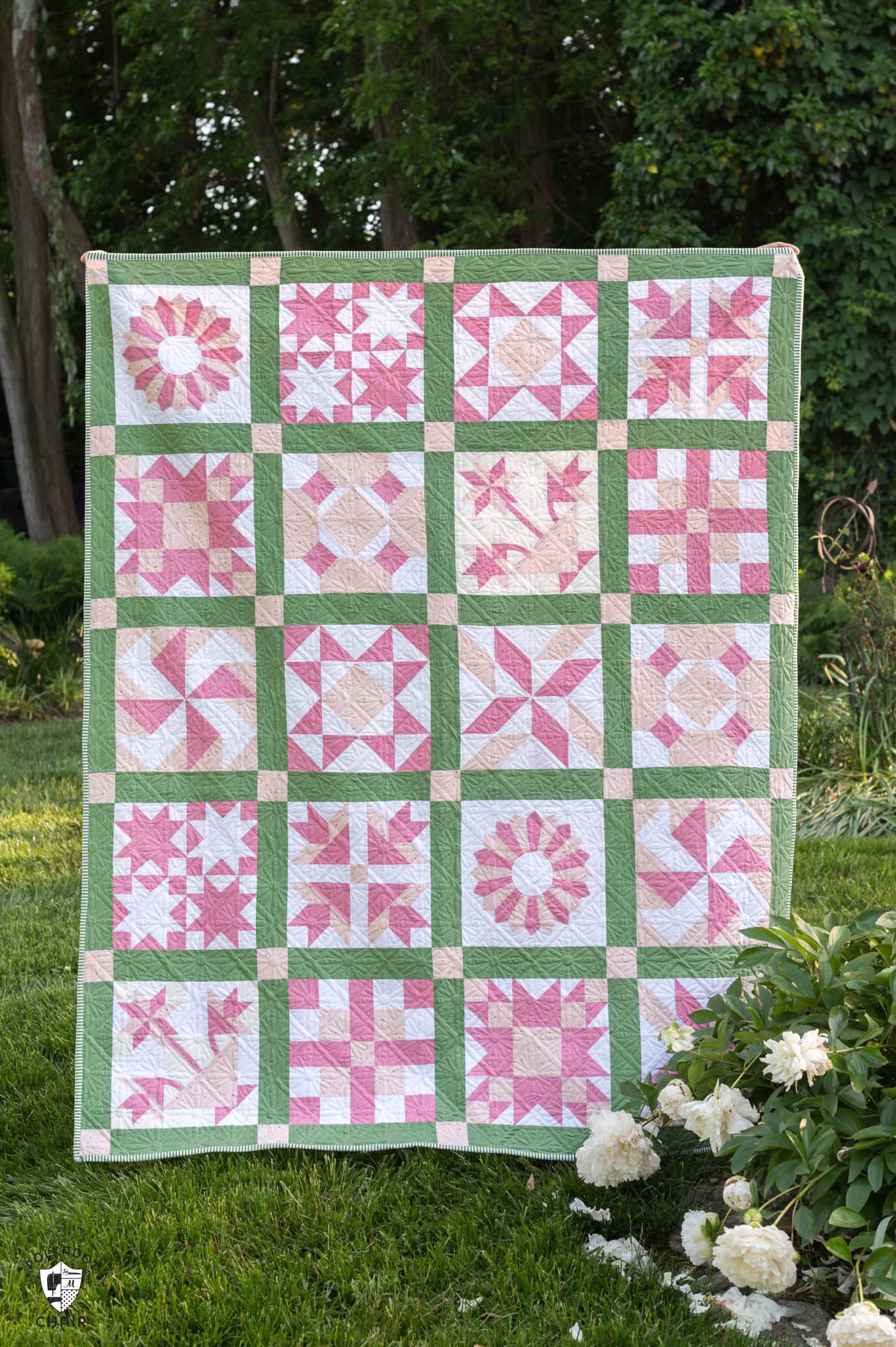pink and green sampler quilt outdoors