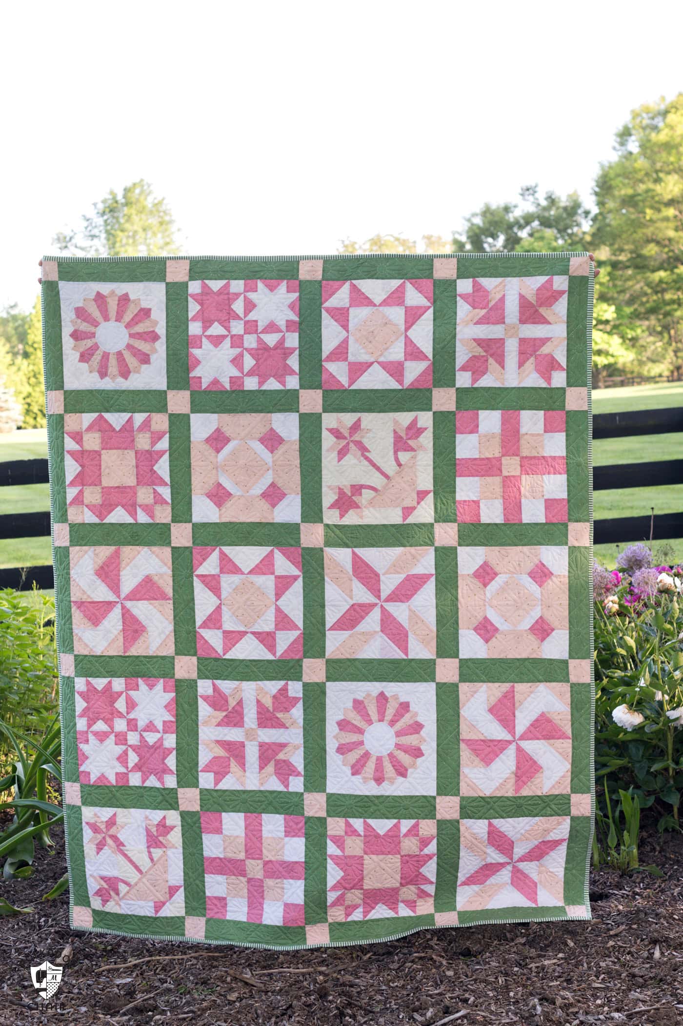 pink and green sampler quilt outdoors